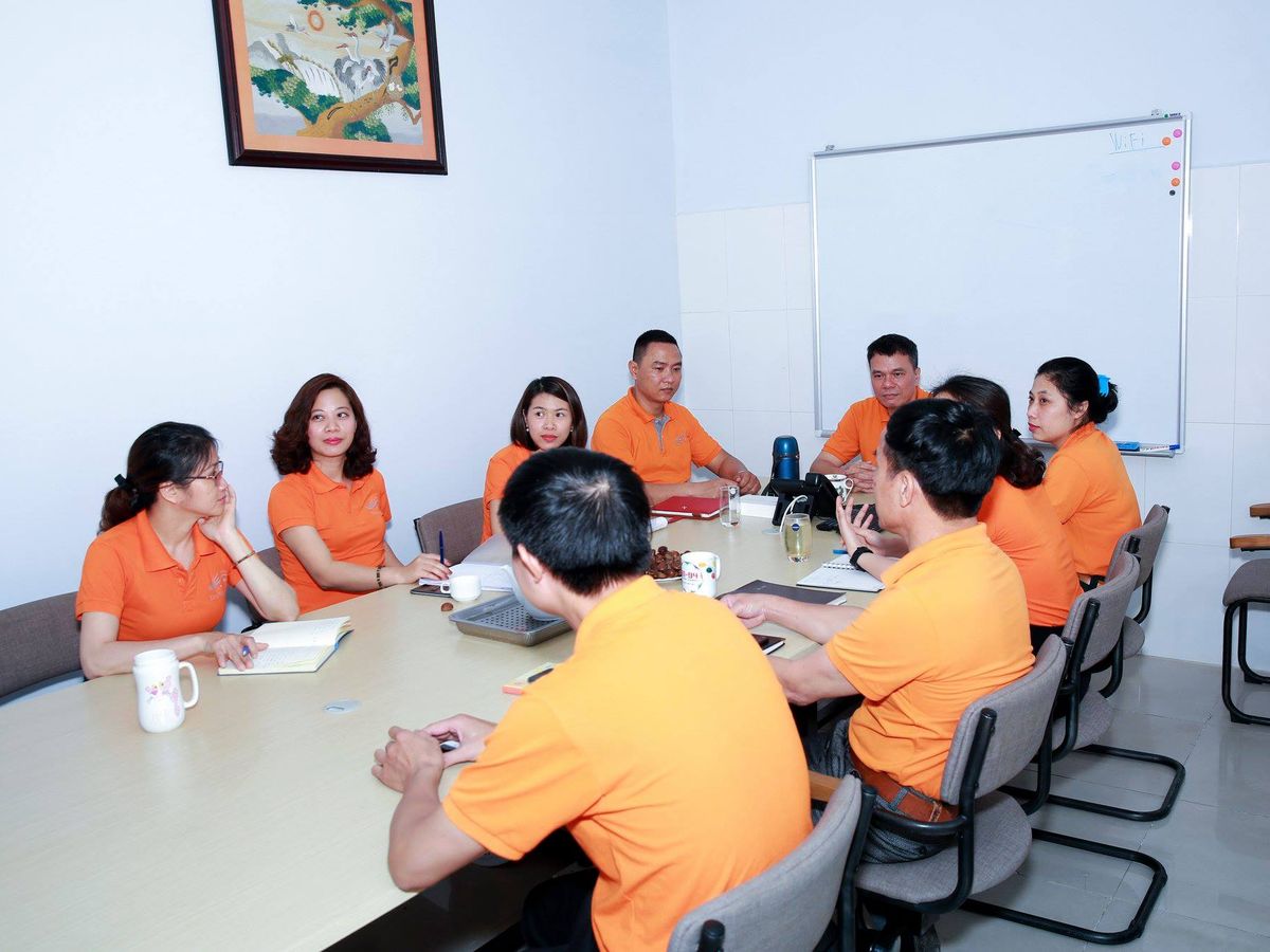Cán bộ Tina Services mặc áo cam trong một buổi họp tại văn phòng