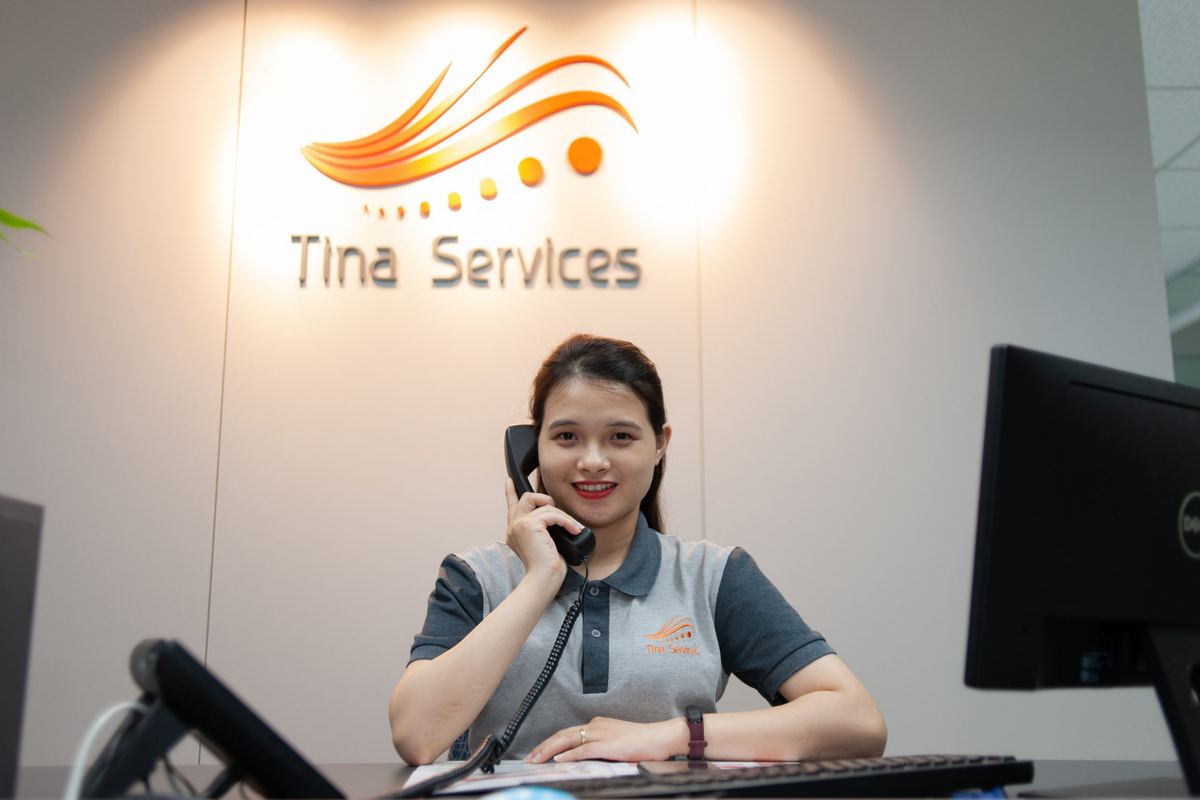 Khu vực tiếp khách văn phòng Tina Services tại Hà Nội, phía sau là logo công ty